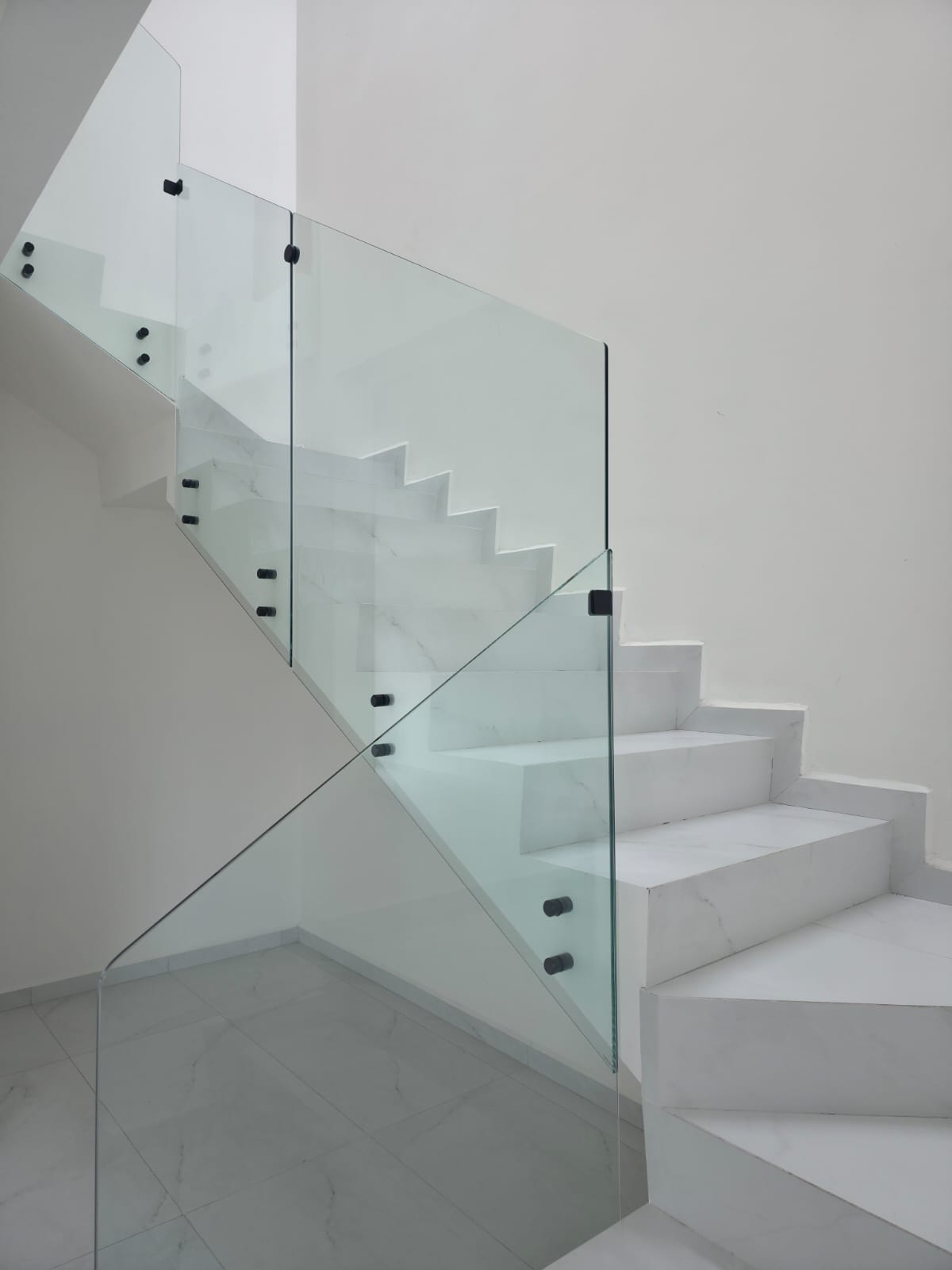 Escalera de mármol con barandal de cristal