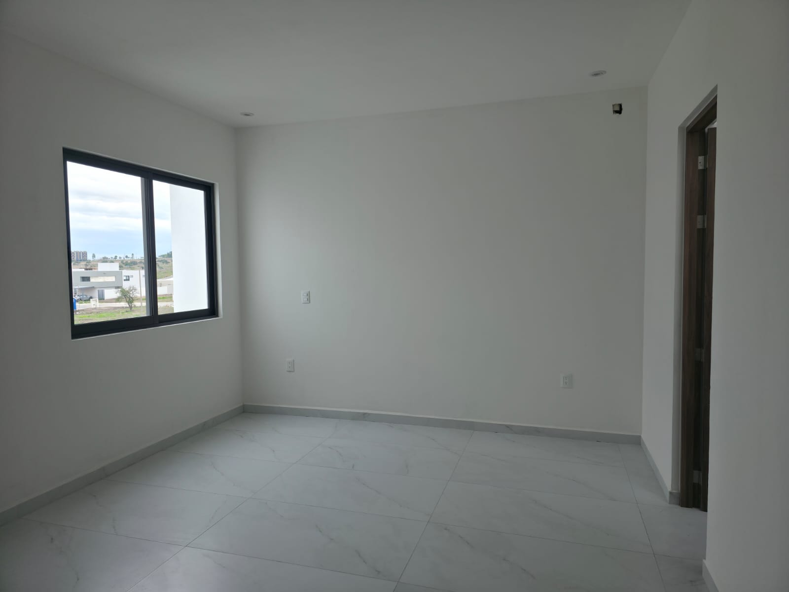Recámara principal con pared de panel de madera