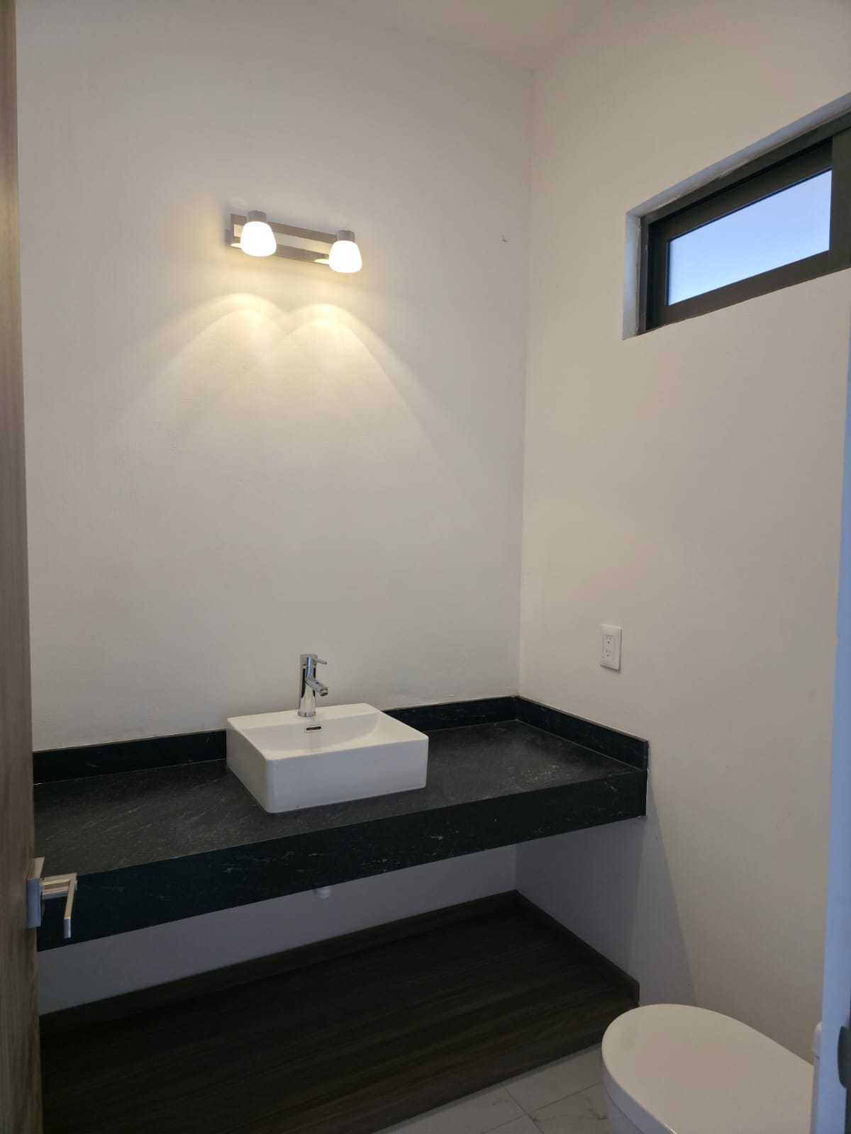 Baño de visitas con cubierta de mármol negro