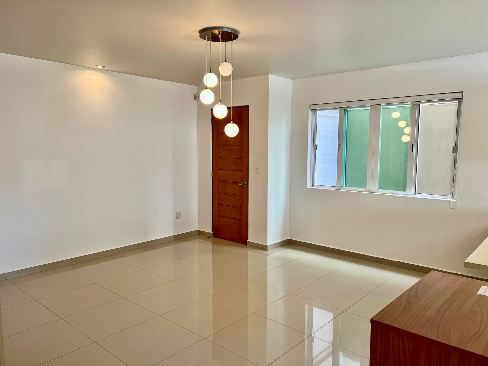Comedor con lámpara de pendants y ventana al patio