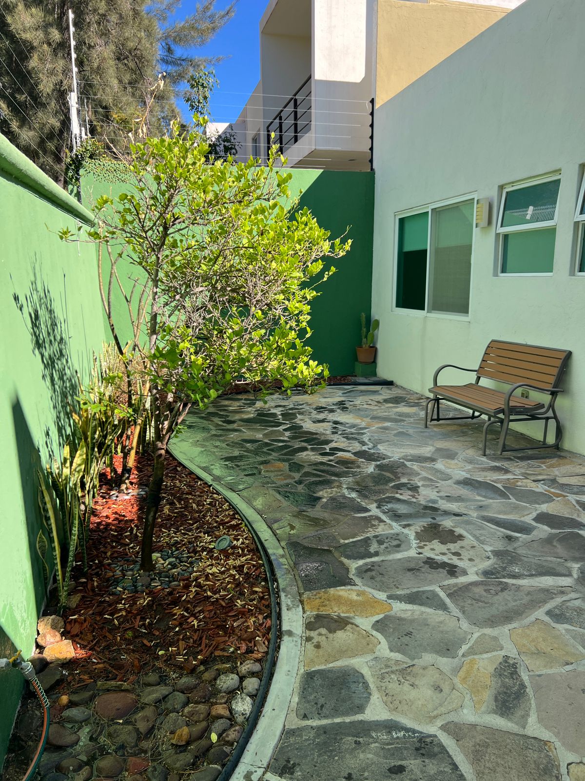 Patio exterior trasero jardinado con piso de piedra