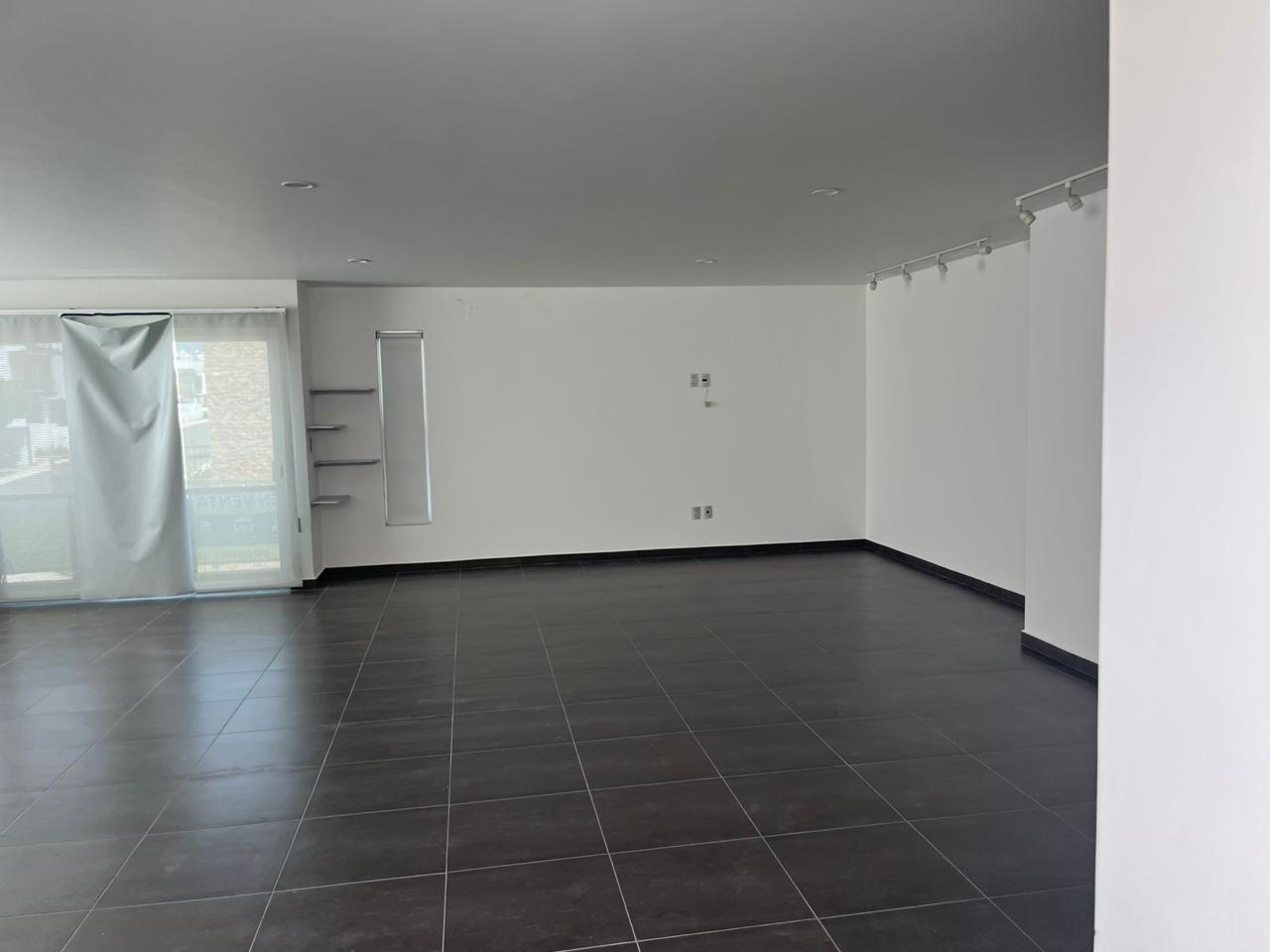 Interior loft 160 m² planta alta con piso oscuro y track lighting
